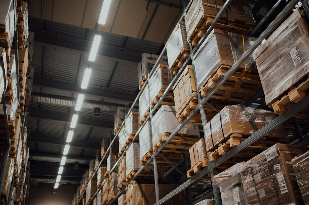 Illustrative warehouse inventory and logistics image for the BRAC procurement and supply chain job guide; photo by CHUTTERSNAP via Unsplash